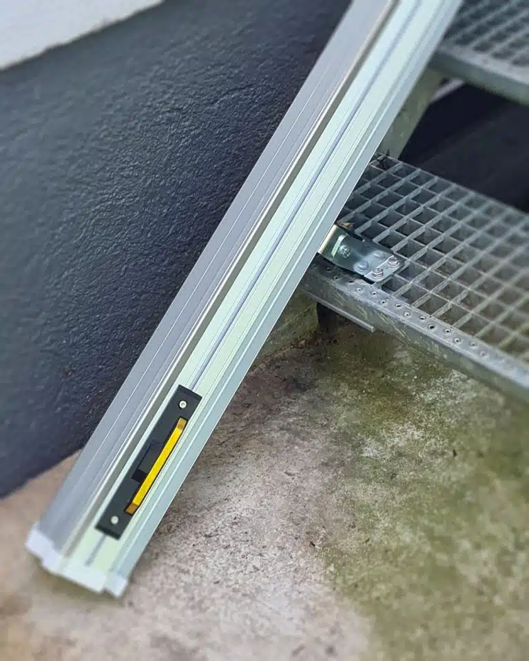 Detailaufnahme der Schienenbefestigung des Platinum Ergo STRAIGHT Outdoor-Treppenlifts auf einer Gitterrosttreppe in Markt Indersdorf.