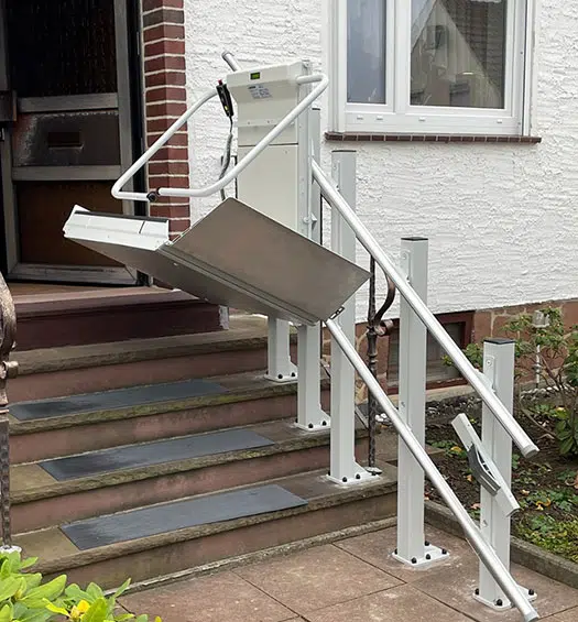 Plattform-Treppenlift im Außenbereich für Rollstuhl an einer Hauseingangstreppe